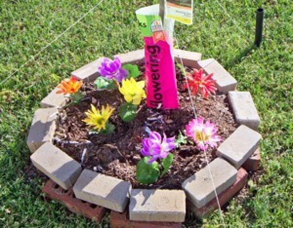 A small flower bed with fake flowers.