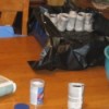 Gardening: Paper Pots - making the pots with completed ones in a plastic bag lined container in the background, closeup