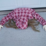 A Halloween decoration of a person  caught under a garage door.