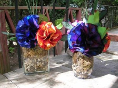 two vases with blue and purple flowers with one red and  yellow one also