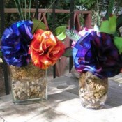 two vases with blue and purple flowers with one red and  yellow one also