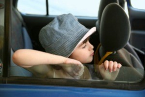 Kid riding in a car.