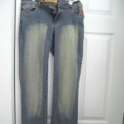 Pair of faded blue jeans hanging in front of door