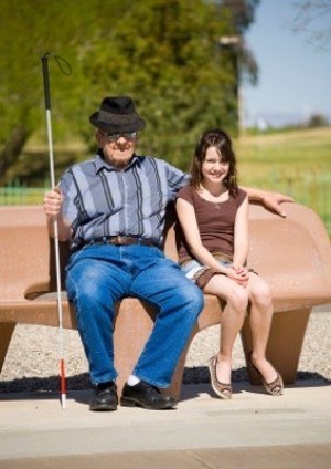 a blind man and a girl sitting on a bench