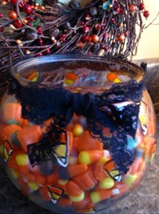 fish bowl filled with candy corn and tied with Halloween ribbon