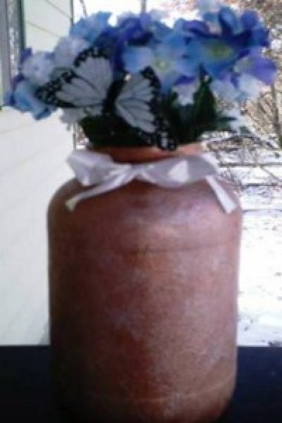 A flower vase made from a recycled jar.