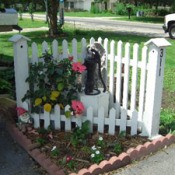 White corner fence in flower bed.