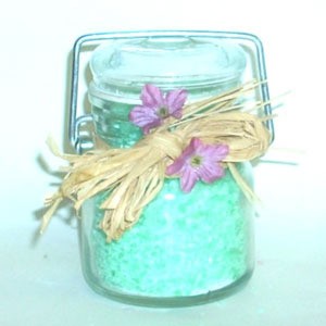 A jar of turquoise colored homemade bath salts.