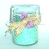 A jar of turquoise colored homemade bath salts.