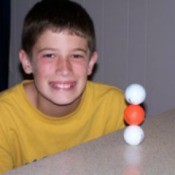 boy posing with balanced golf balls