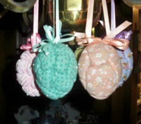 Easter eggs with a quilted appearance hanging from a chandelier.