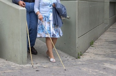 Blind man and woman walking down a ramp.