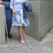 Blind man and woman walking down a ramp.