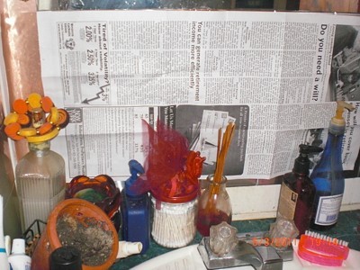 Newspaper Shield When Steam Cleaning - Newspaper taped up behind small bottles.