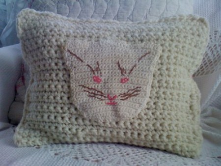 Cat pot holder attached to crochet pillow.