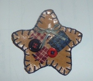 Paper star pin decorated with buttons and fabric.