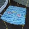 A chair seat covered with a cheerful blue seat cover with fish.