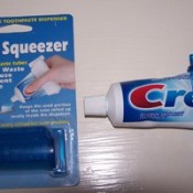 A tube of toothpaste with a tube squeezer.