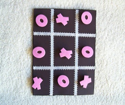 Black game board with pink Xs and Os.