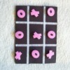 Black game board with pink Xs and Os.