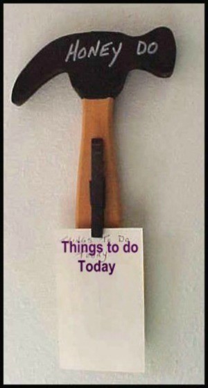 wooden cutout of a hammer with a clothespin to hold a list of "to do projects"