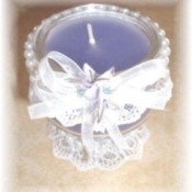 Decorated candle in glass stemmed dish.