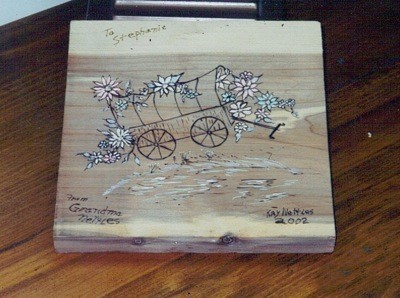 wood burned covered wagon and floral plaque