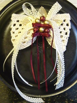 Crocheted hair bow with ribbon trim.