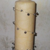 A candle wrapped in wire and charms.