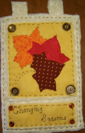 Decorative tabbed quilt with fall motif.