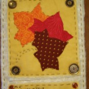 Decorative tabbed quilt with fall motif.