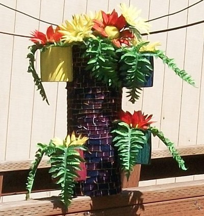 A recycled planter with faux fall flowers.