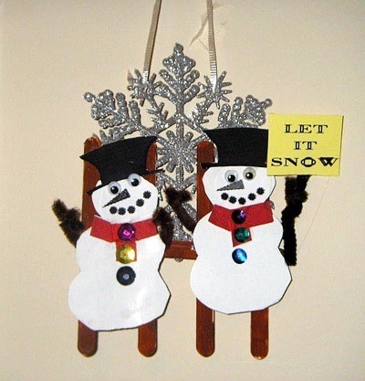 snowmen against fence with a large snowflake