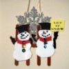 snowmen against fence with a large snowflake