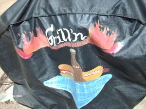 Painted design (hot dog and a soda) on black grill cover.