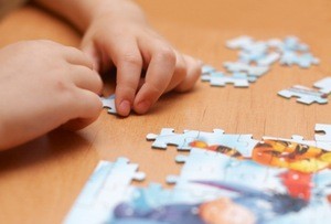 Small hands putting together a puzzle