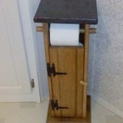 Toilet paper holder built to resemble an outhouse.