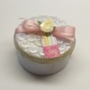 Round box decorated with buttons and pink ribbon.