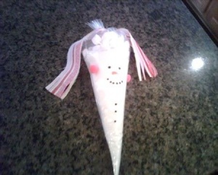 Hot chocolate mix in a plastic cone shaped bag, decorated like a snowman.