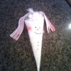 Hot chocolate mix in a plastic cone shaped bag, decorated like a snowman.