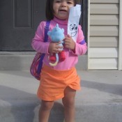 A small girl dressed as Dora the Explorer.