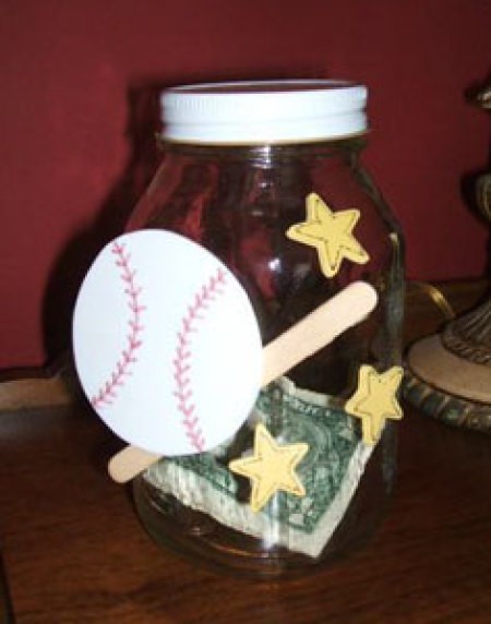 A piggy bank made from a recycled jar decorated with baseball motifs.