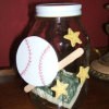 A piggy bank made from a recycled jar decorated with baseball motifs.