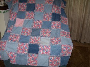 A denim and pink quilt made from recycled fabrics.
