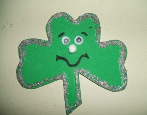 A green shamrock shaped pin made out of foam.