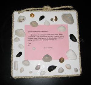 Foam board decorated with seashells and a poem or other saying.