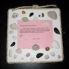Foam board decorated with seashells and a poem or other saying.