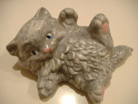 A ceramic kitty that has been painted.