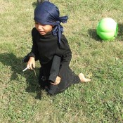 A girl dressed in a black spider costume.