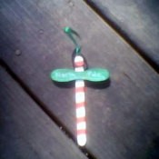 A homemade Christmas ornament that resembles a striped North Pole sign.
